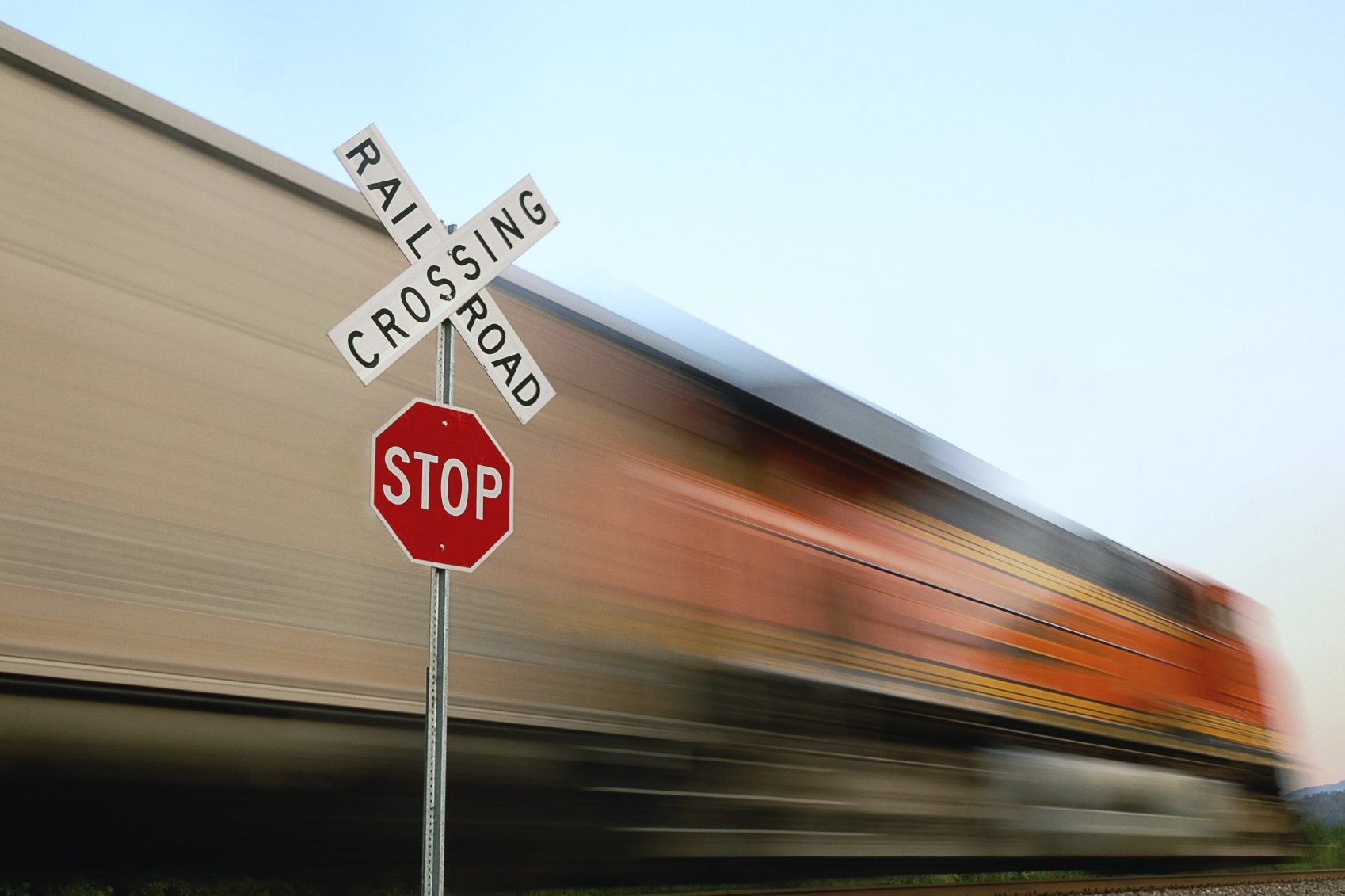 Railroad crossing sign in front of a passing train